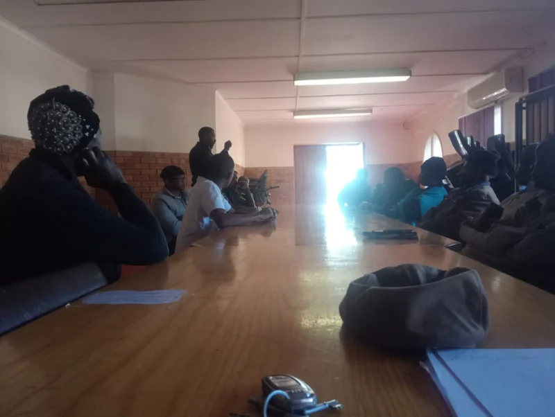 Residents seated around a long table at a Burgersdorp Development Agency community meeting.